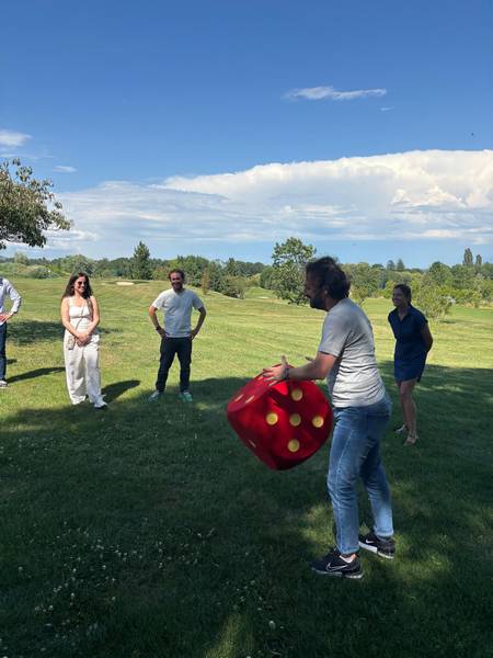 Participant lançant le dé géant pendant une animation team building du jeu de l'oie géant à Annecy