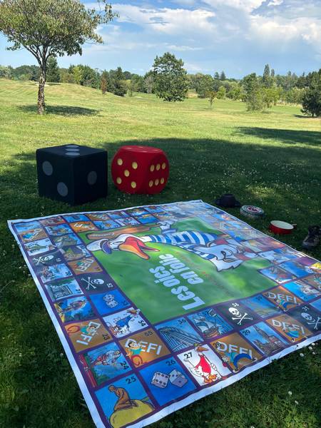 Plateau du jeu de l'oie géant et dés géants sur la pelouse face au lac d'Annecy
